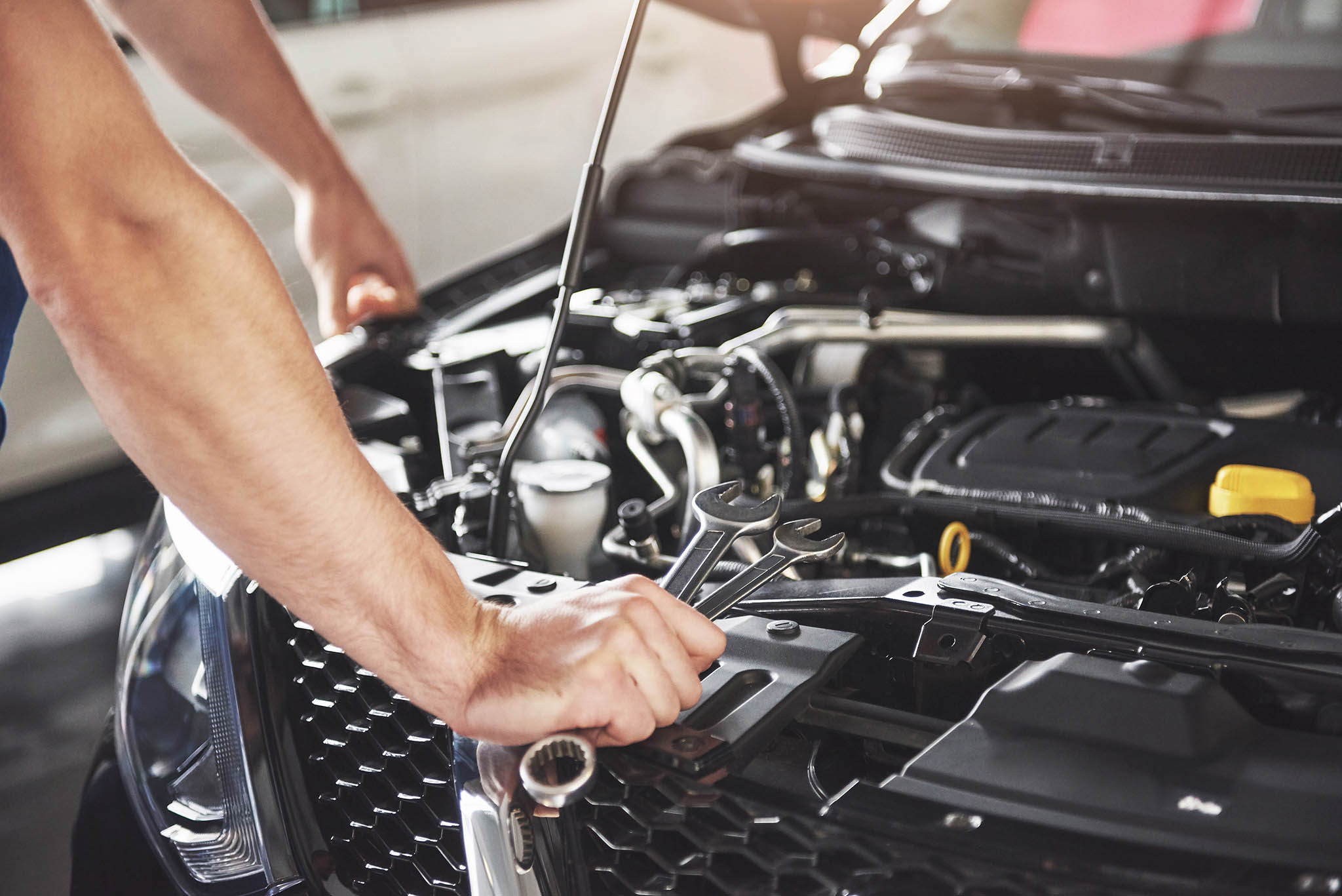 Car mechanic doing a car service and maintenance.