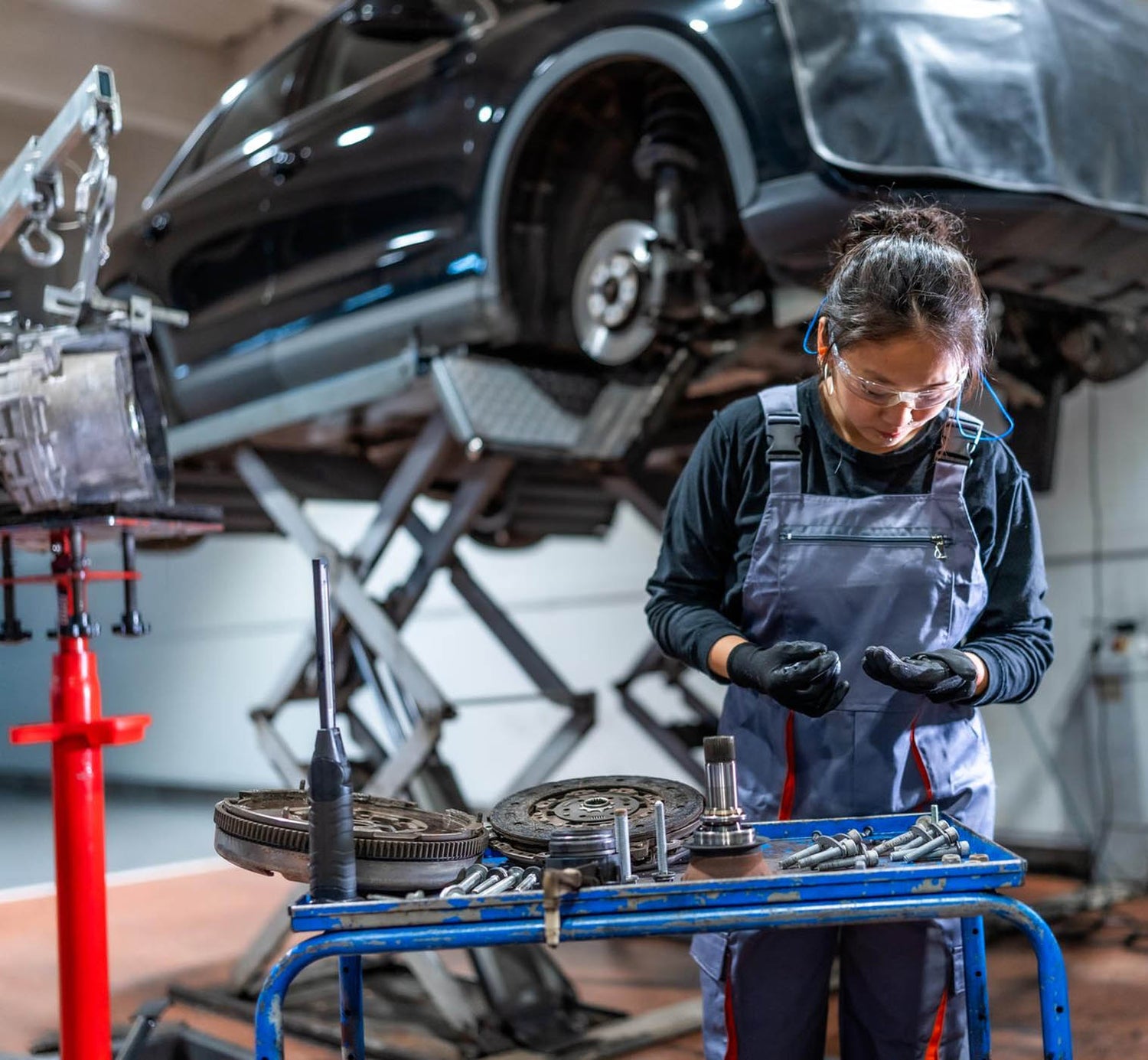 Female car mechanic working on a vehicle in a car garage business.