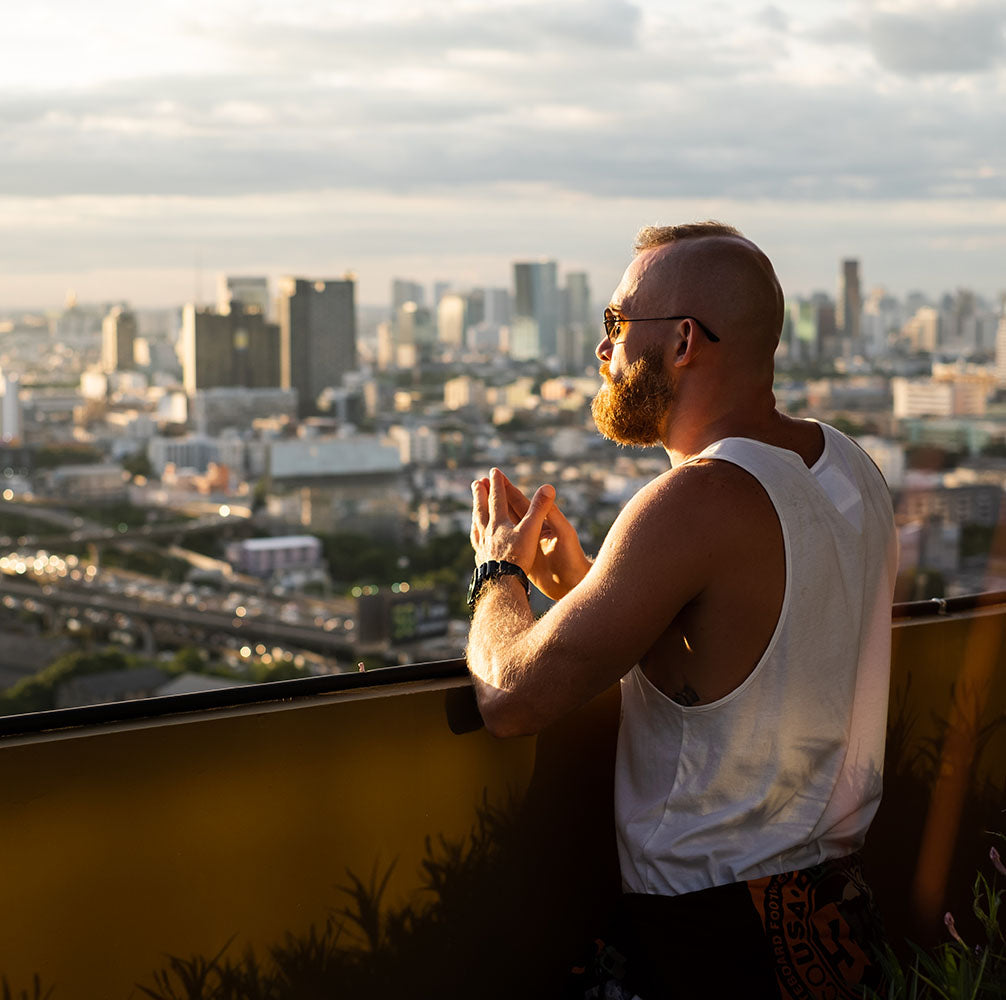 Man on balcony of holiday let apartment looking at a city view.
