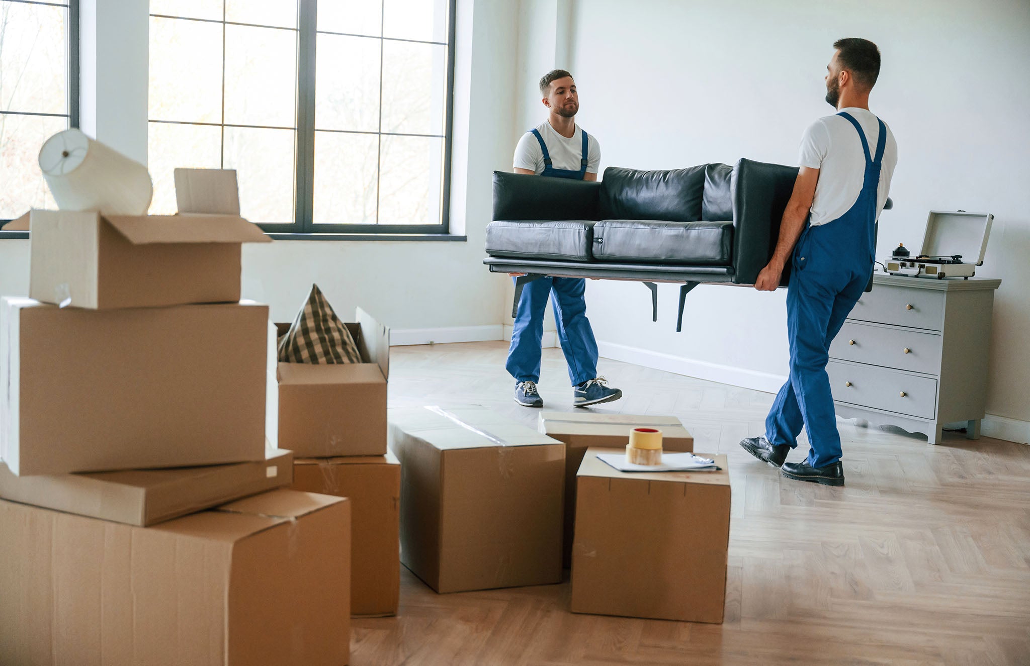 Removal company employees moving large furniture.