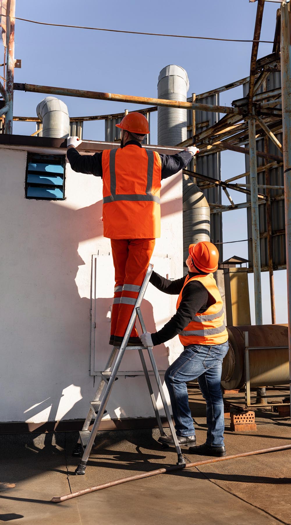 Workers using ladder on construction site