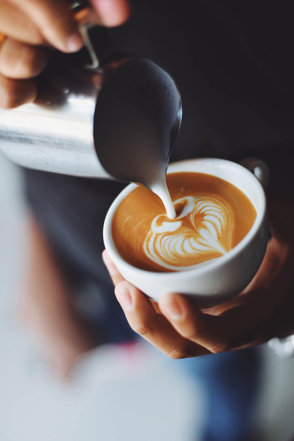 Barista pouring a fresh cup of coffee.