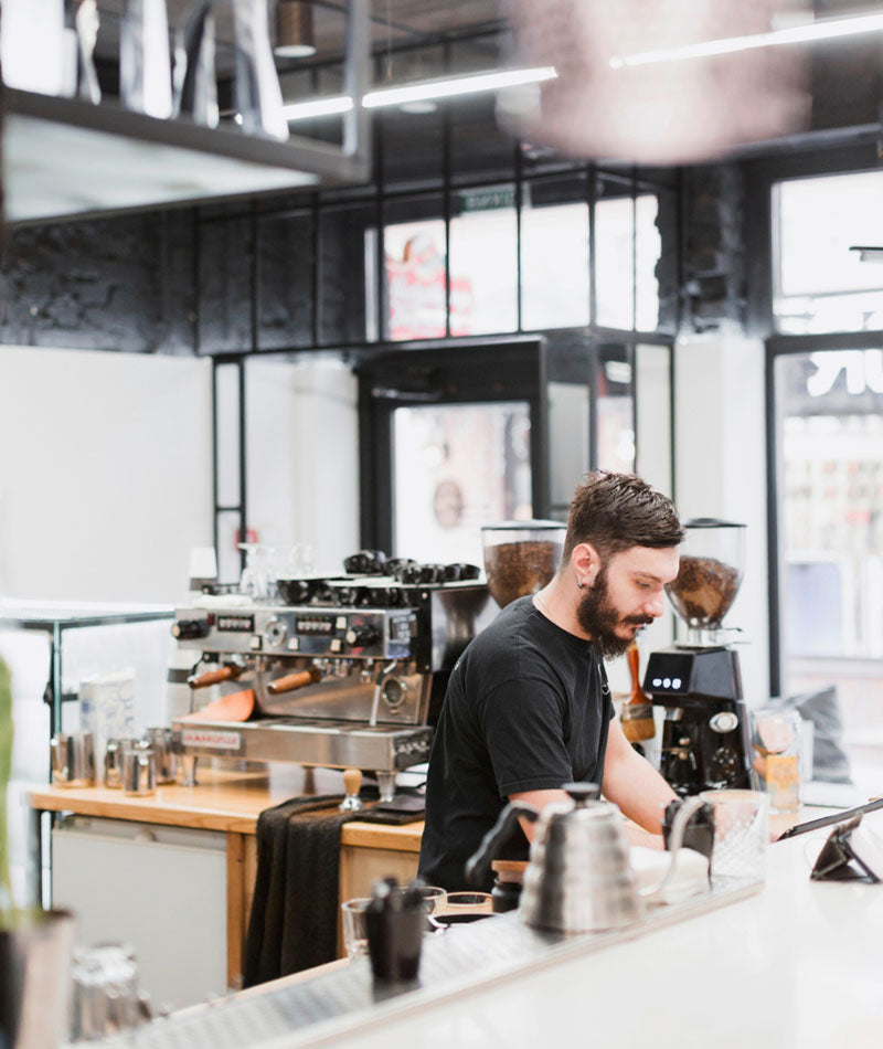 Barista serving customers in an industrial style coffee shop