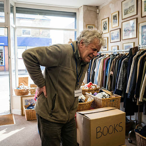 A charity shop worker who has injured his back after lifting heavy items.