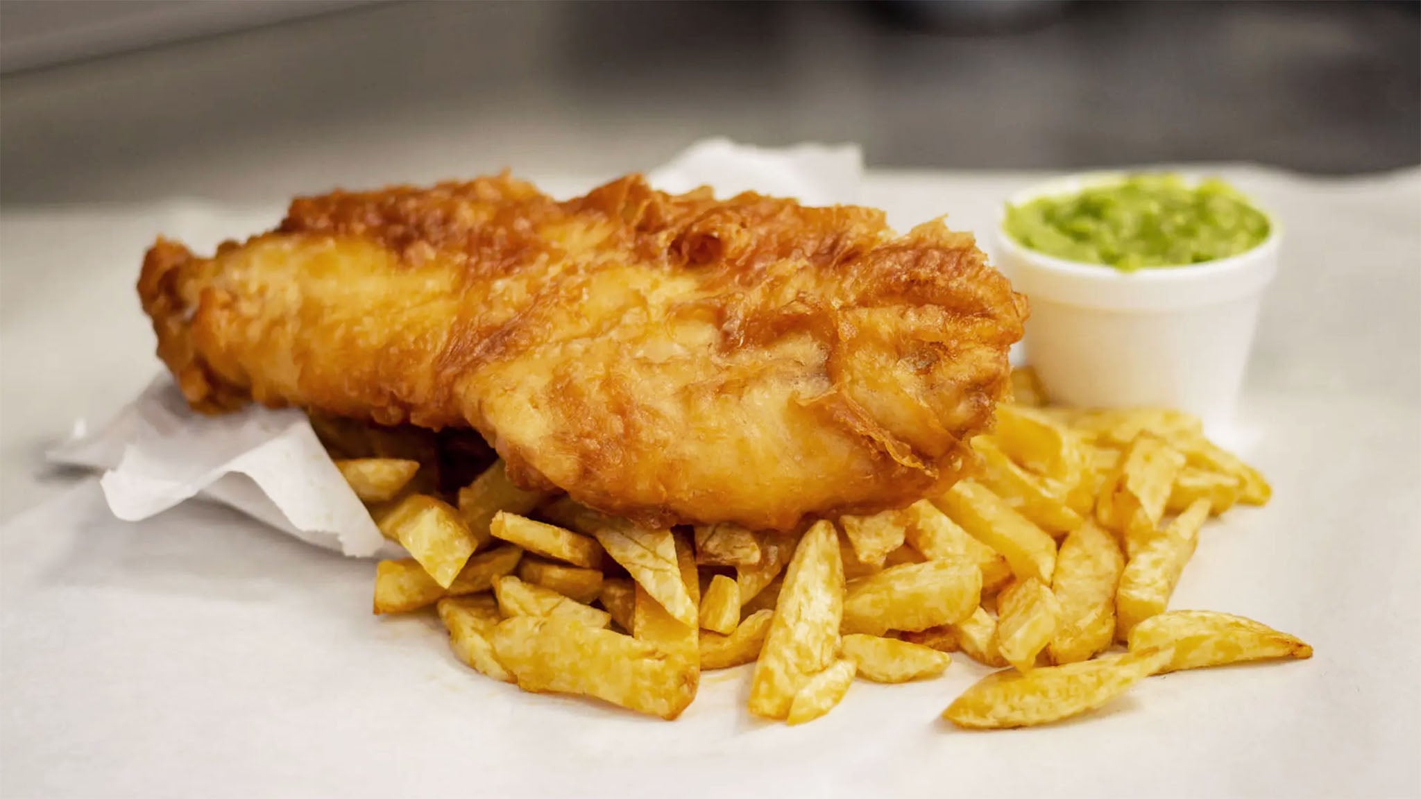 A freshly cooked portion of fish and chips from a fish and chip shop restaurant.