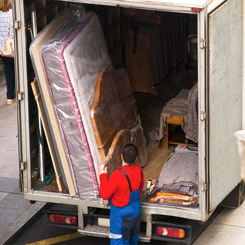A furniture removal worker unloading a van.