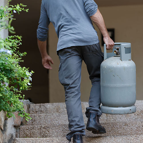 A mobile coffee shop owner carrying a gas canister.