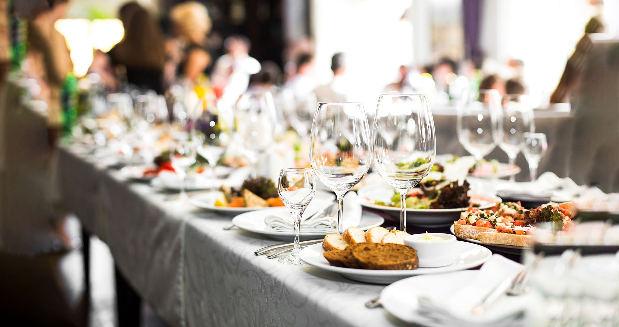 A professional event catering setup with food and wine glasses.