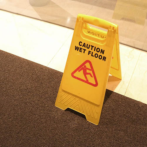 A wet floor sign in the entrance to a charity shop.