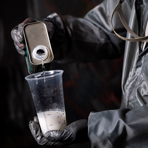 Car body shop worker mixing paints and solvents.