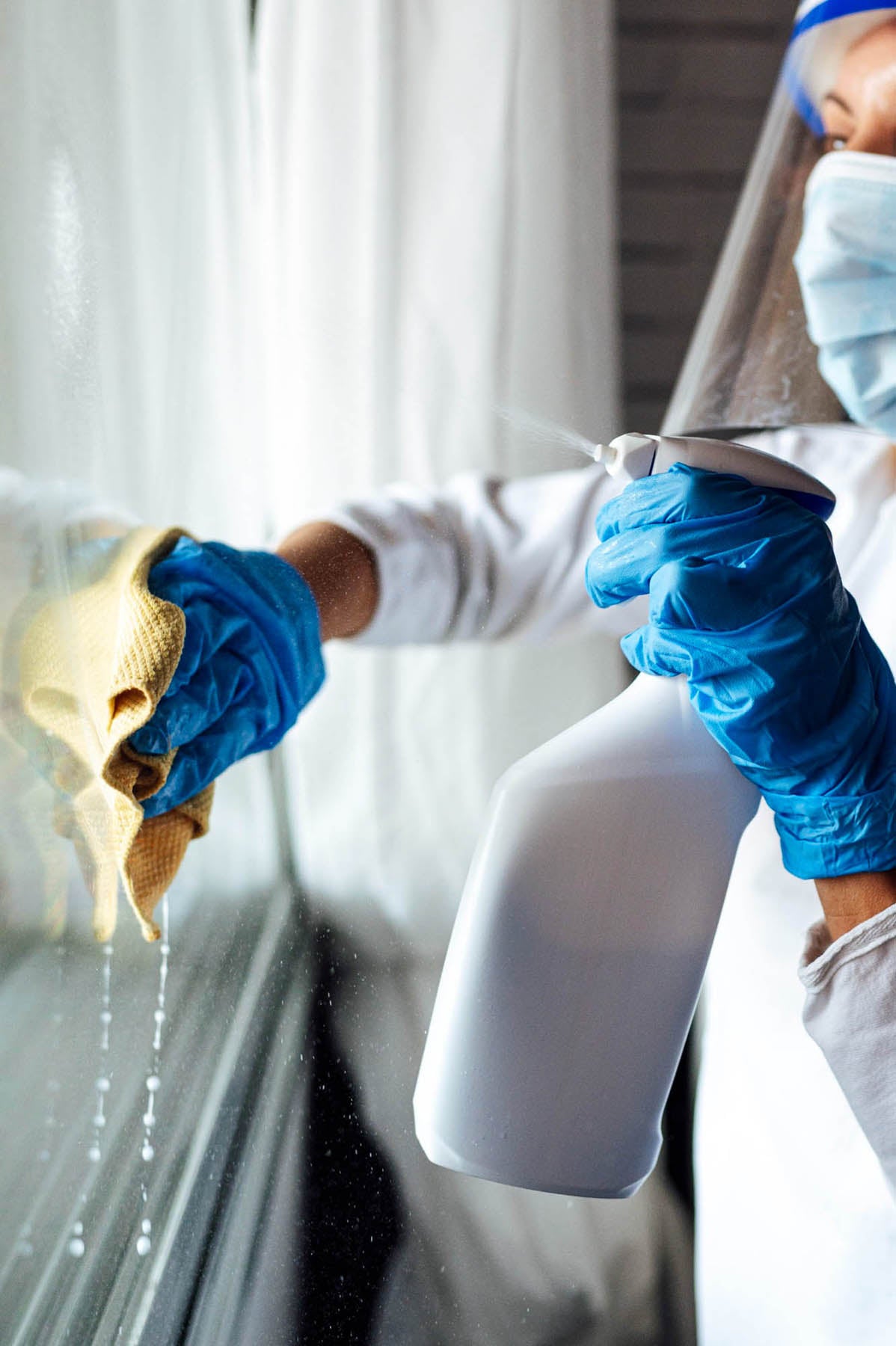 Cleaning staff disinfecting surfaces whilst wearing ppe