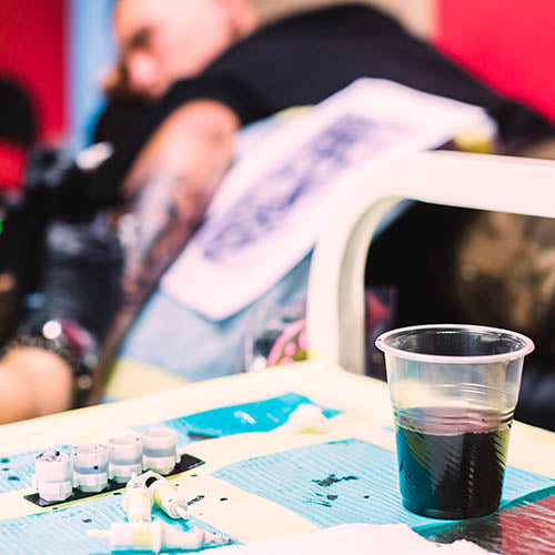 Desk with tattoo inks and hazardous waste.