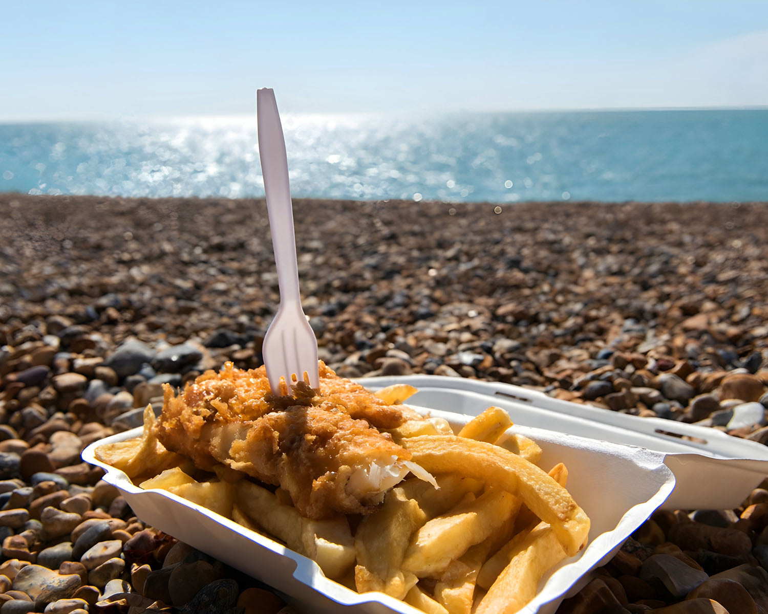Fish and chips on beach from a fish and chip shop.