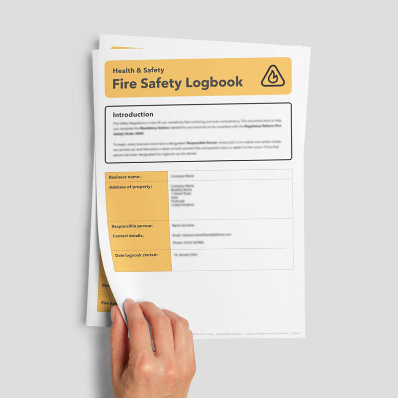Hand flicking through fire safety log book document