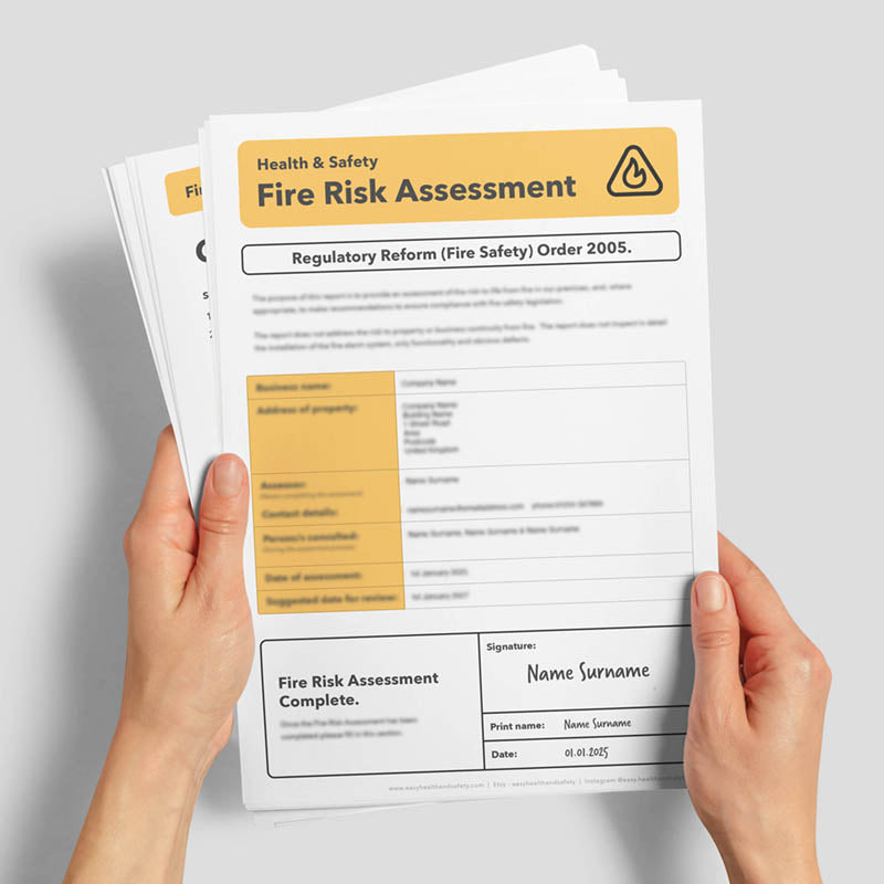 Hands holding a fire risk assessment document