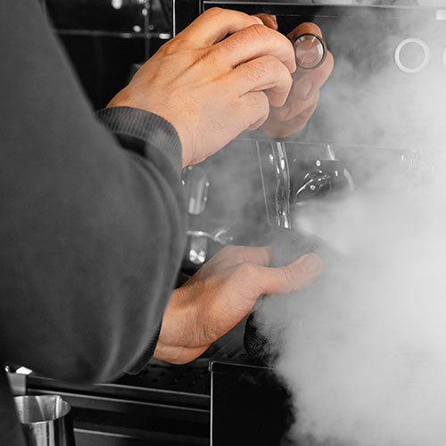 Hot steam coming from a coffee machine.