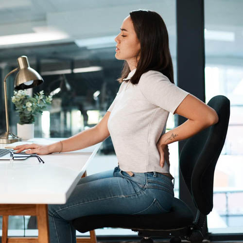Office worker suffering from back pain due to poor working posture