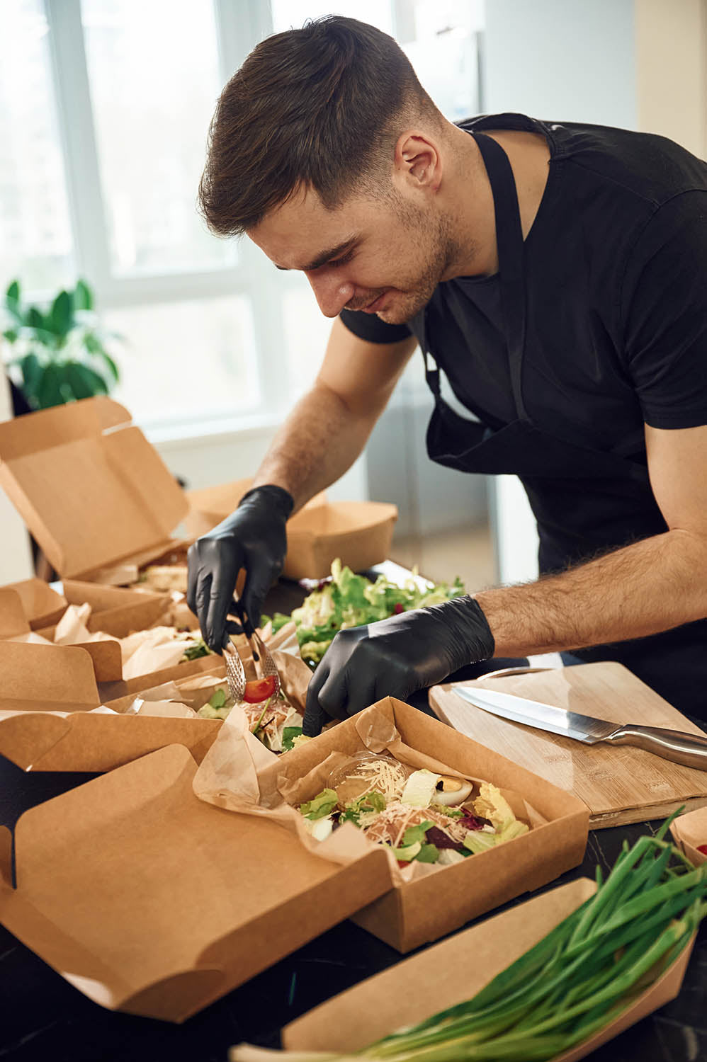 Takeaway restaurant owner preparing meals for customers.