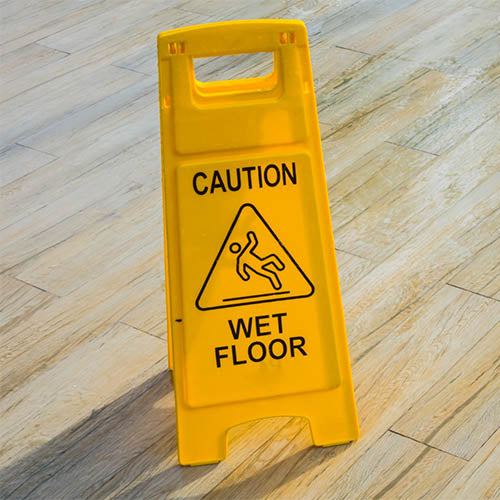 Wet floor sign on a tanning shop floor.
