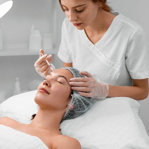 Beautician doing filler injection female client.