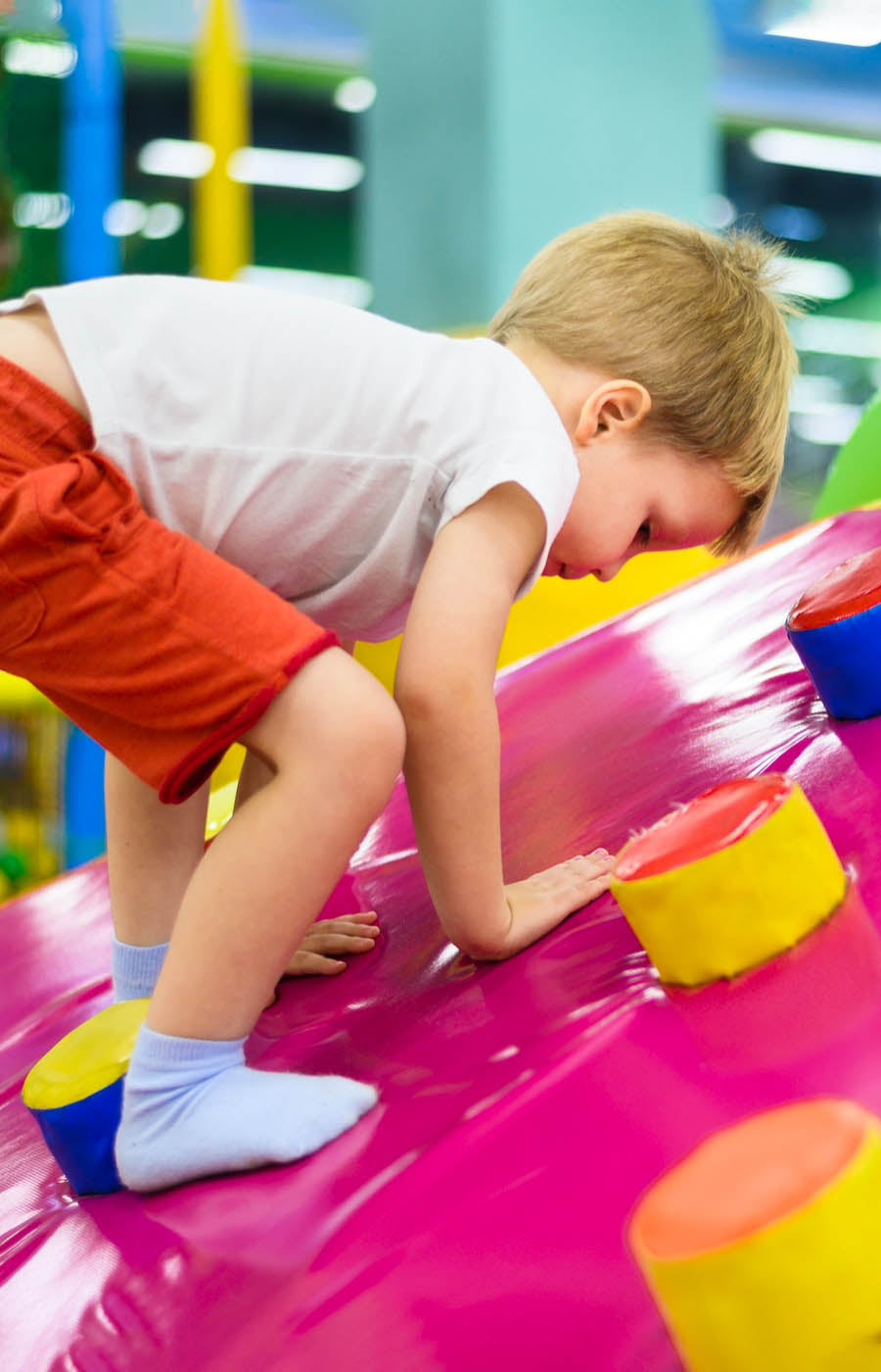 Young boy playing on indoor soft play equipment