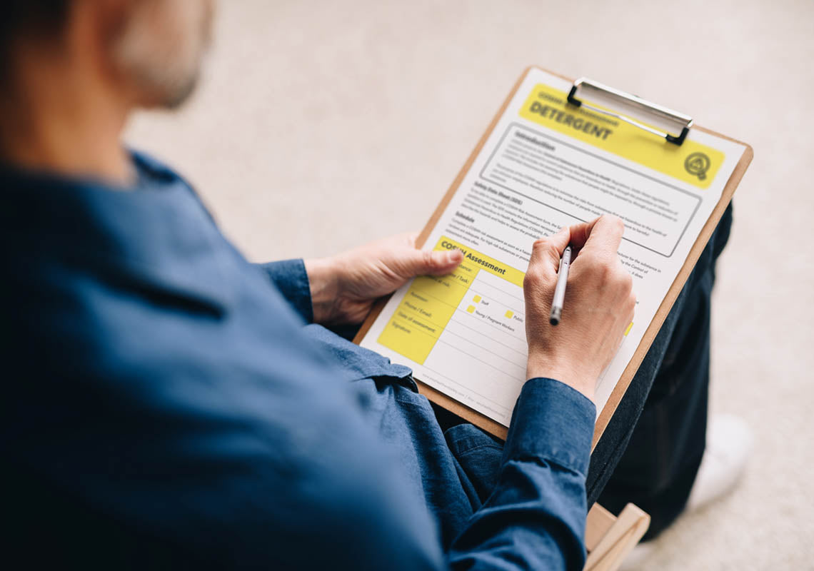 A business owner filling in a coshh assessment for detergent