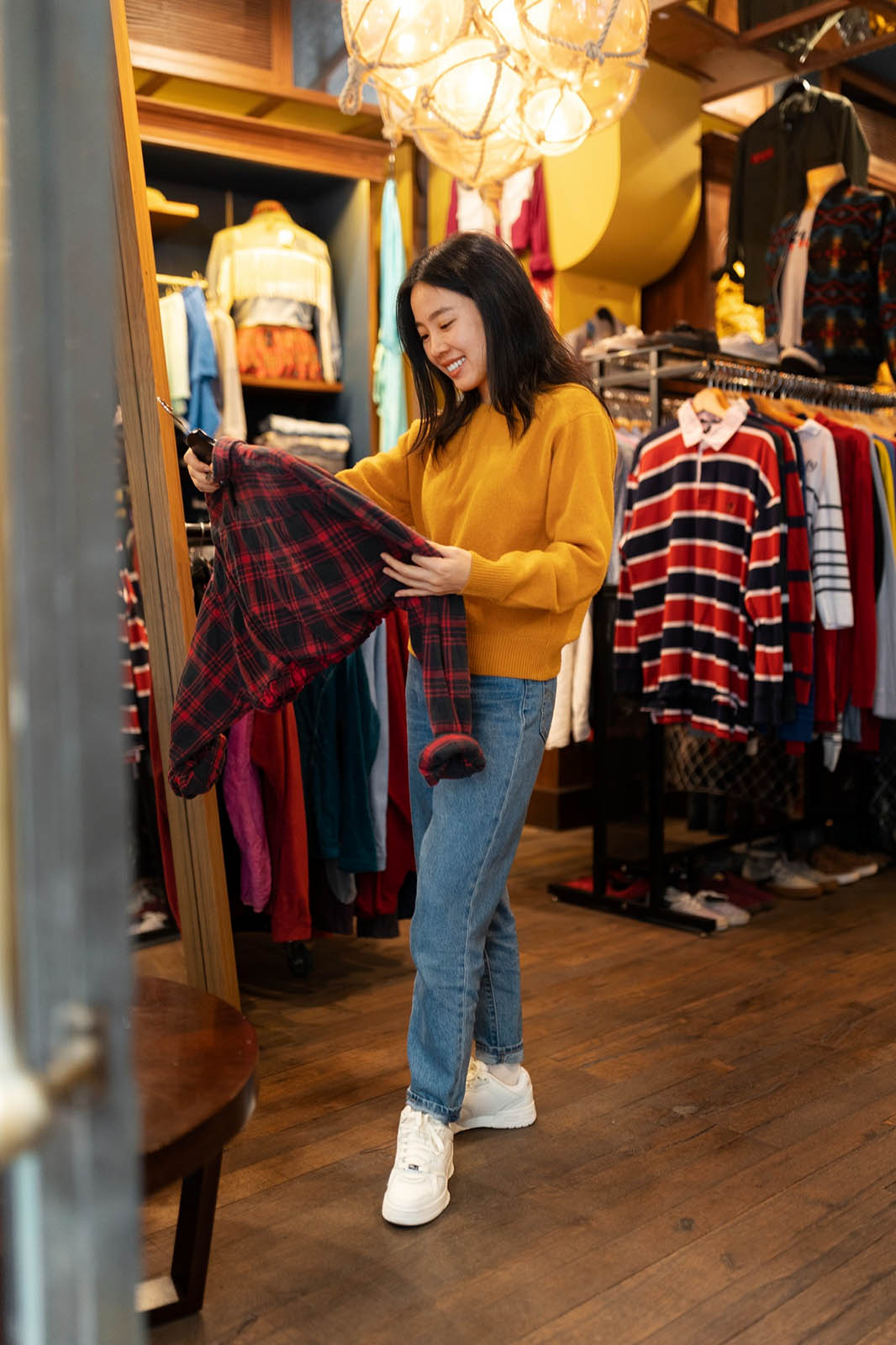 Customer browsing second-hand clothing inside a charity shop, showing a typical charity retail environment.