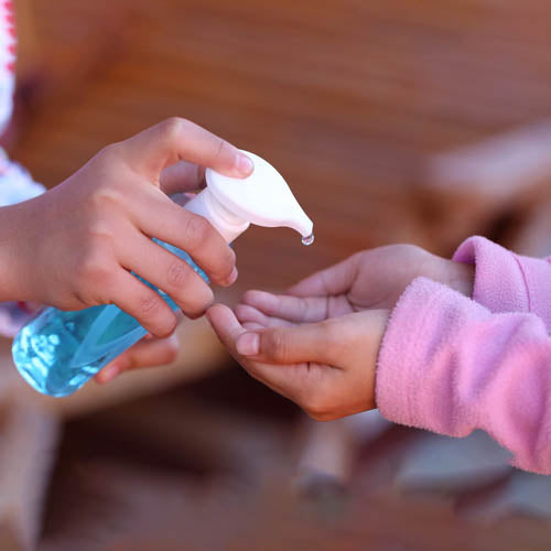 Child being given some hand sanitising gel