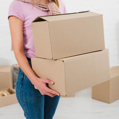 female holding two heavy looking boxes