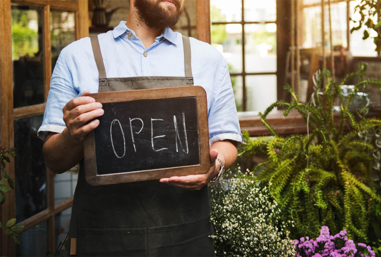 Business owner holding open sign