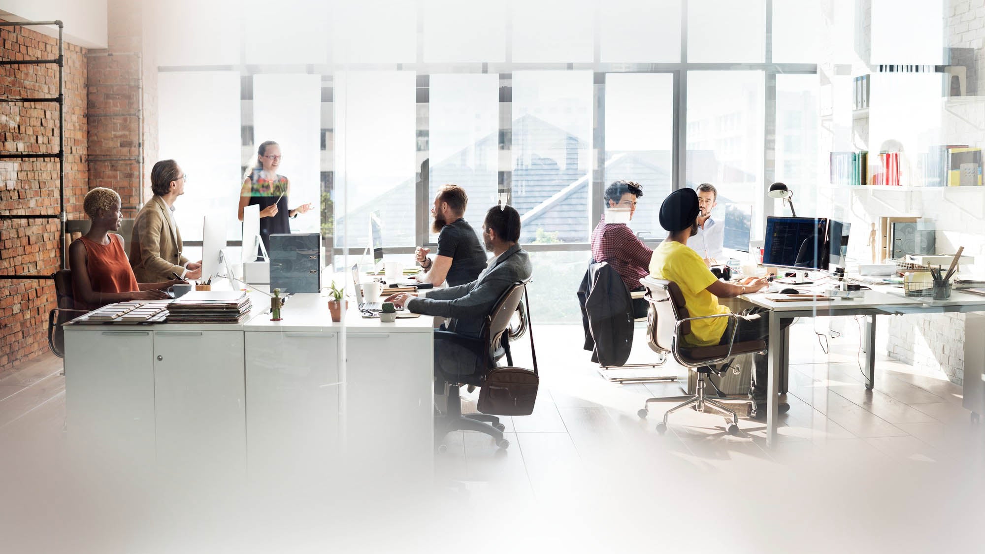 Office workplace with employees sat at desks