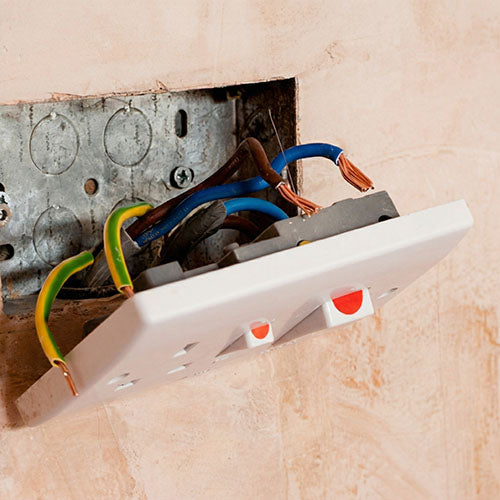 Plug socket hanging away from the wall showing bare electrical wires.