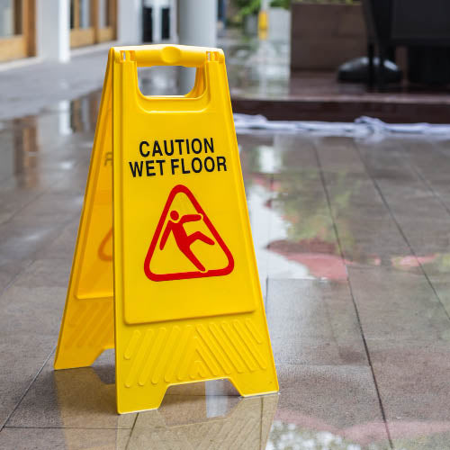 Yellow wet floor sign on a wet floor